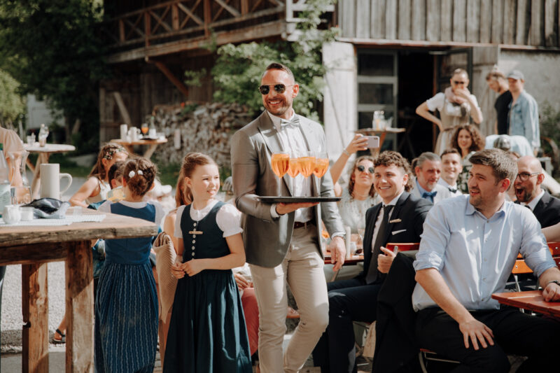 Gast bringt der Hochzeitsgesellschaft ein Tablett mit Aperol Spritz.