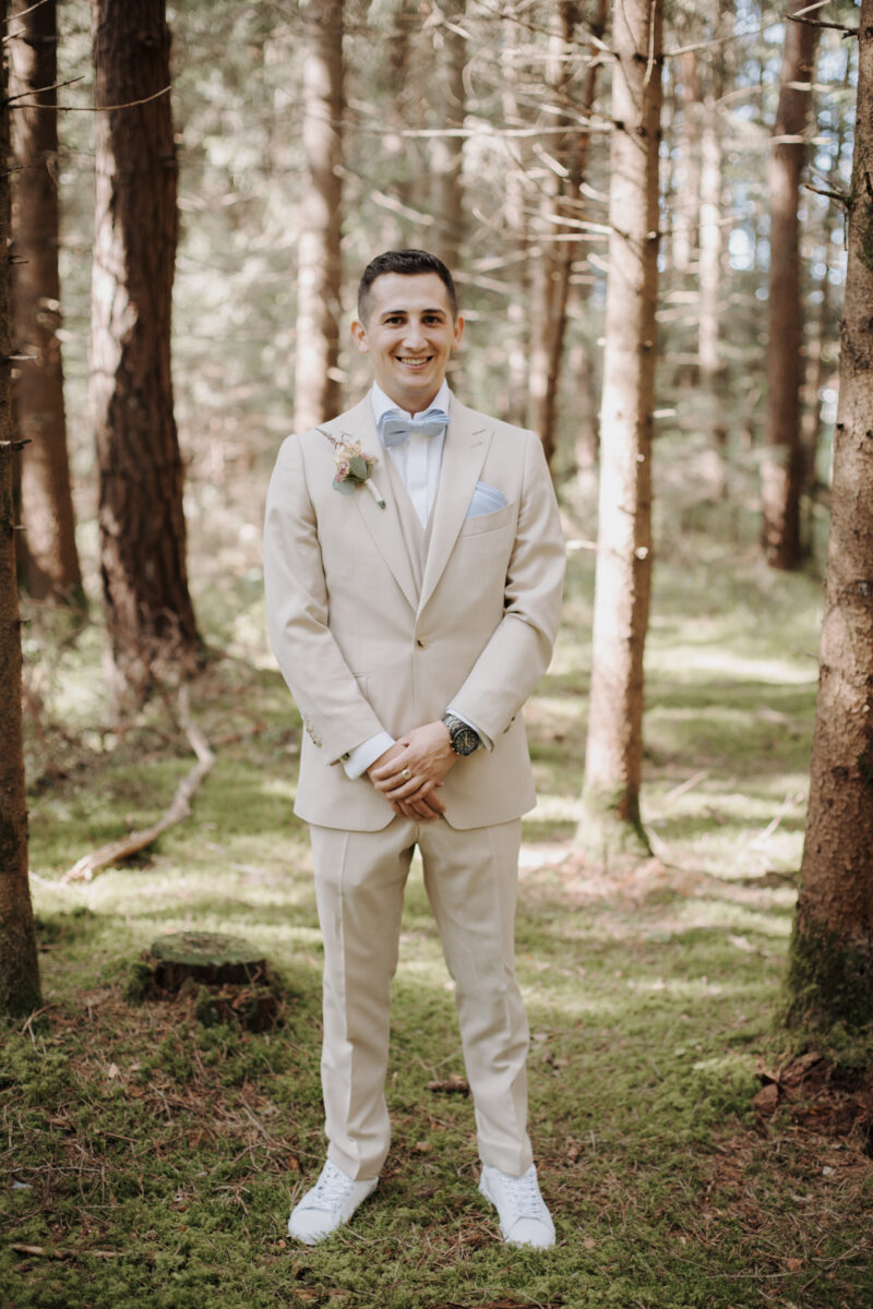 Bräutigam im Hochzeitsanzug im Wald des Filzenklas