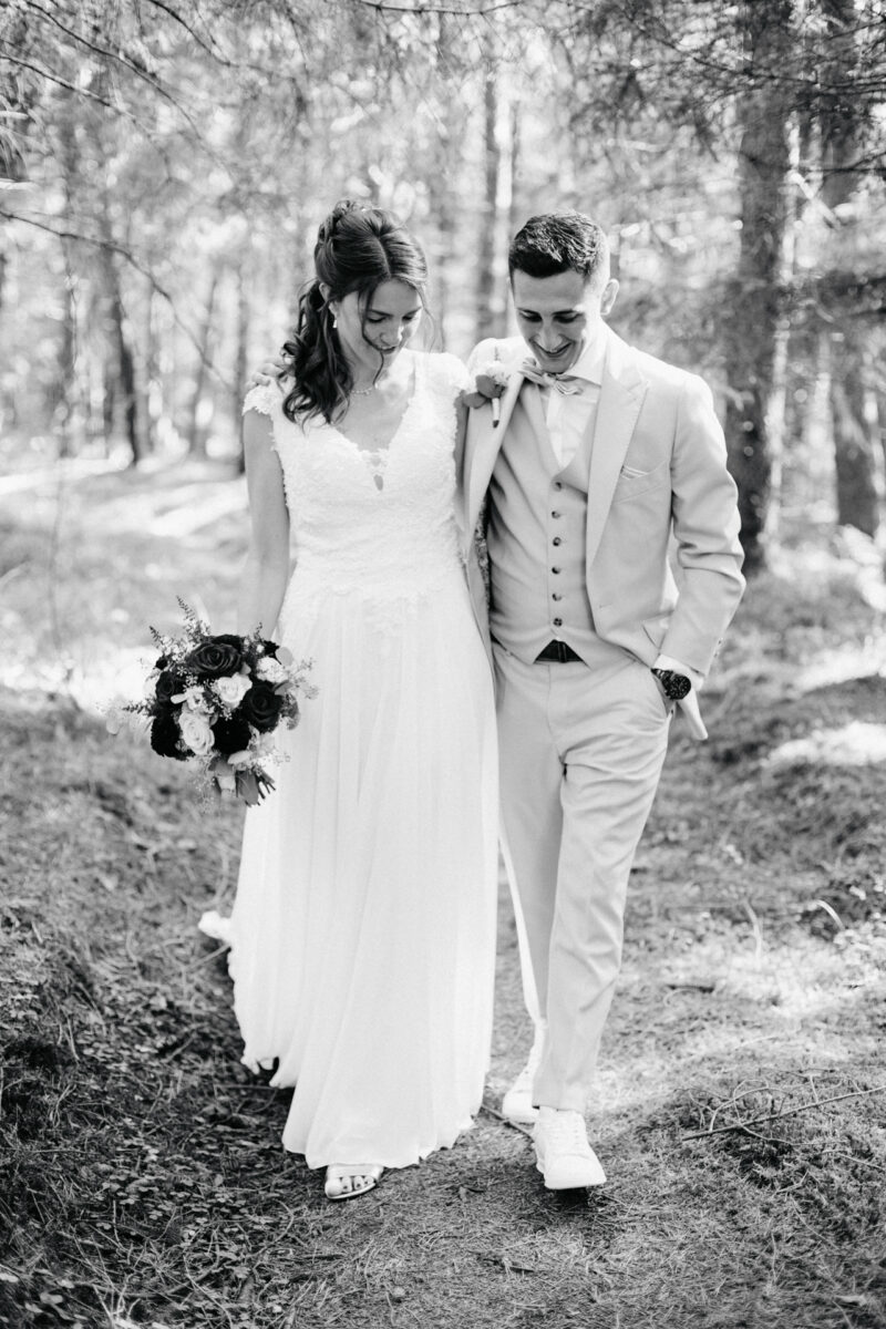 Brautpaar spaziert Arm in Armim Wald des Filzenklas