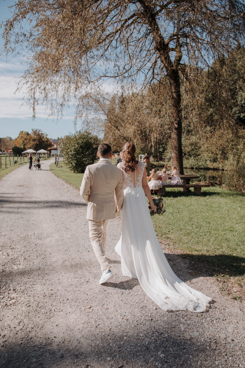 Brautpaar geht nach der Trauung am Weiher des Filzenklas den Weg entlang