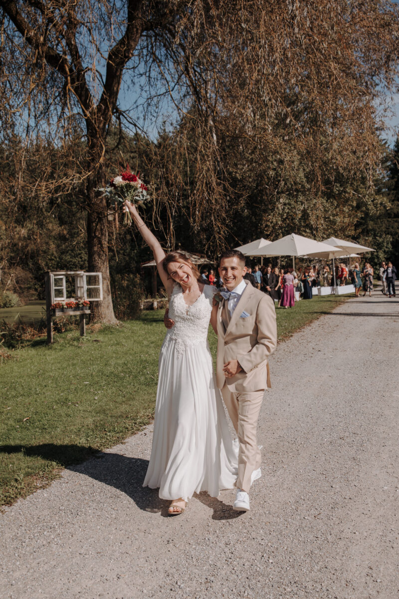 Brautpaar geht nach der Trauung am Weiher des Filzenklas den Gang entlang