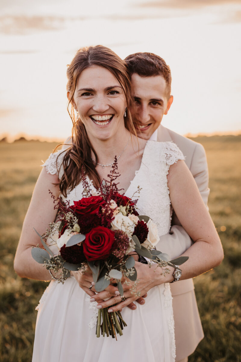 Nahaufnahme des Brautpaars bei einem liebevollen Blick in die Kamera.