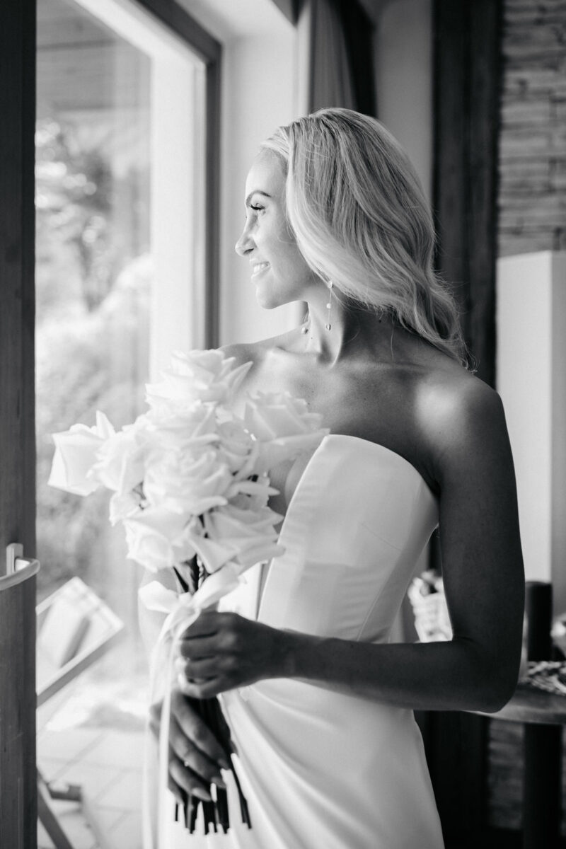 Braut schaut voller Vorfreude aus dem Fenster, kurz vor der Trauung.