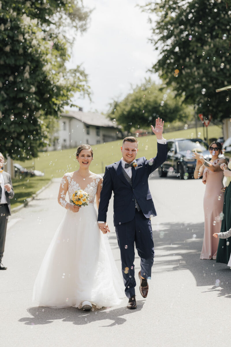 Brautpaar schreitet durch das Spalier der Gäste beim Eintreffen an der Hochzeitslocation - Nahaufnahme