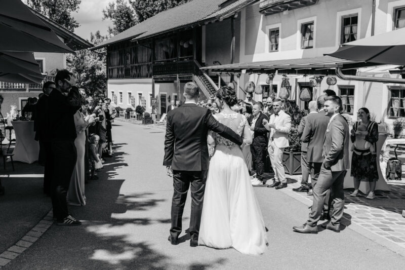 Brautpaar wird herzlich an der Hochzeitslocation Mühle Holzham von Gästen empfangen