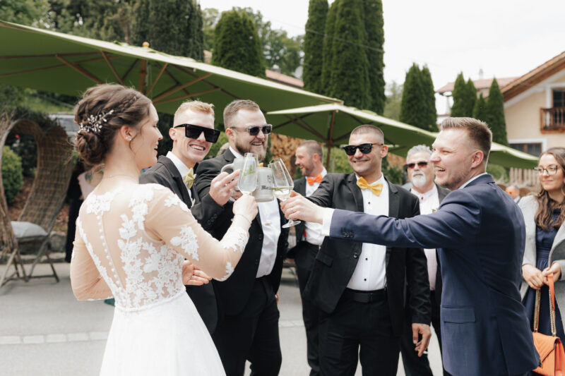 Hochzeitsgäste stoßen gemeinsam mit dem Brautpaar an