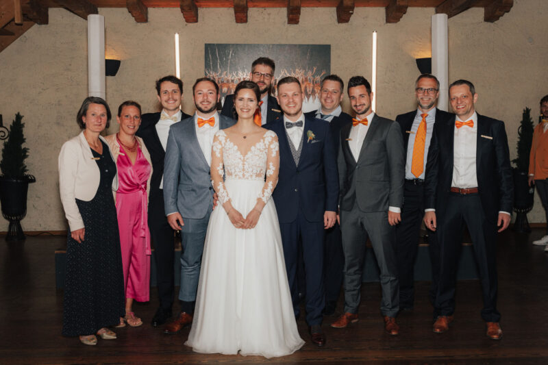 Gruppenbild mit Brautpaar und Hochzeitsgästen während der Feier an der Mühle in Holzham