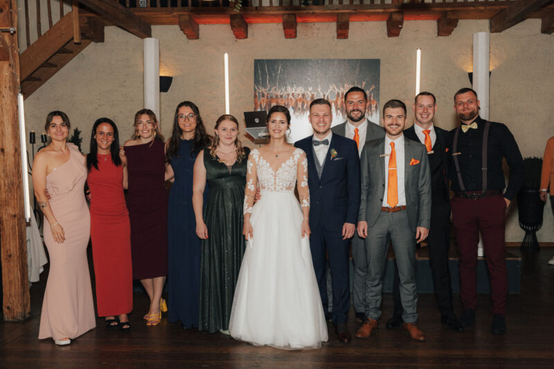 Gruppenbild mit Brautpaar und Hochzeitsgästen während der Feier an der Mühle in Holzham