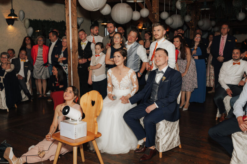 Das Brautpaar und die Gäste sehen sich eine Diashow an