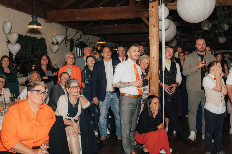 Hochzeitsgäste im Hochzeitsaal in Holzham während einer Einlage