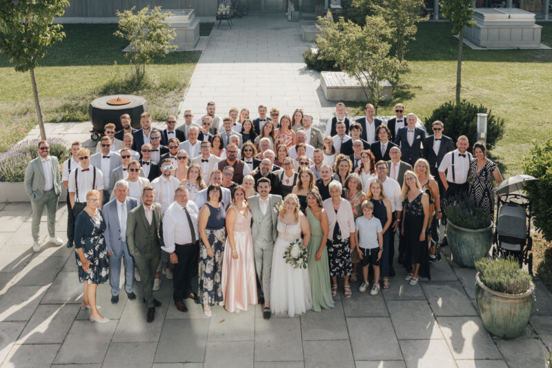 Gruppenbild mit Brautpaar und Hochzeitsgästen beim Dinzler Irschenberg