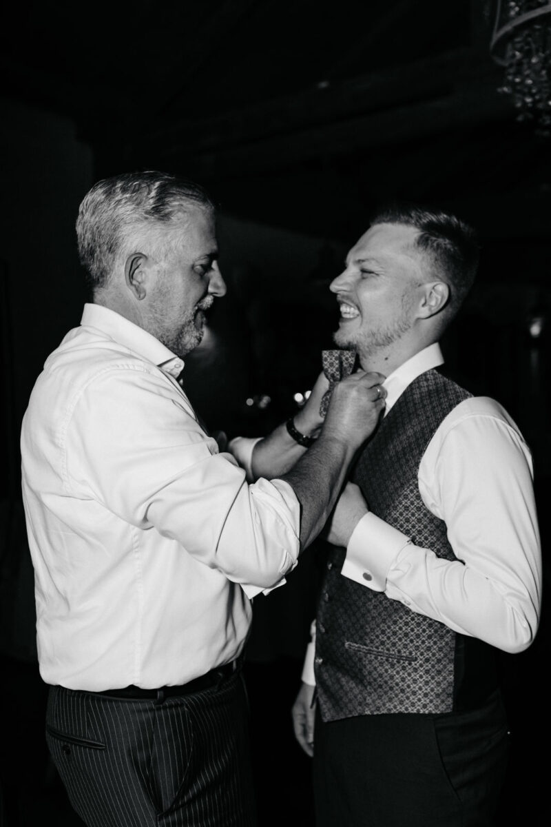 Gast bindet dem Bräutigam die Fliege