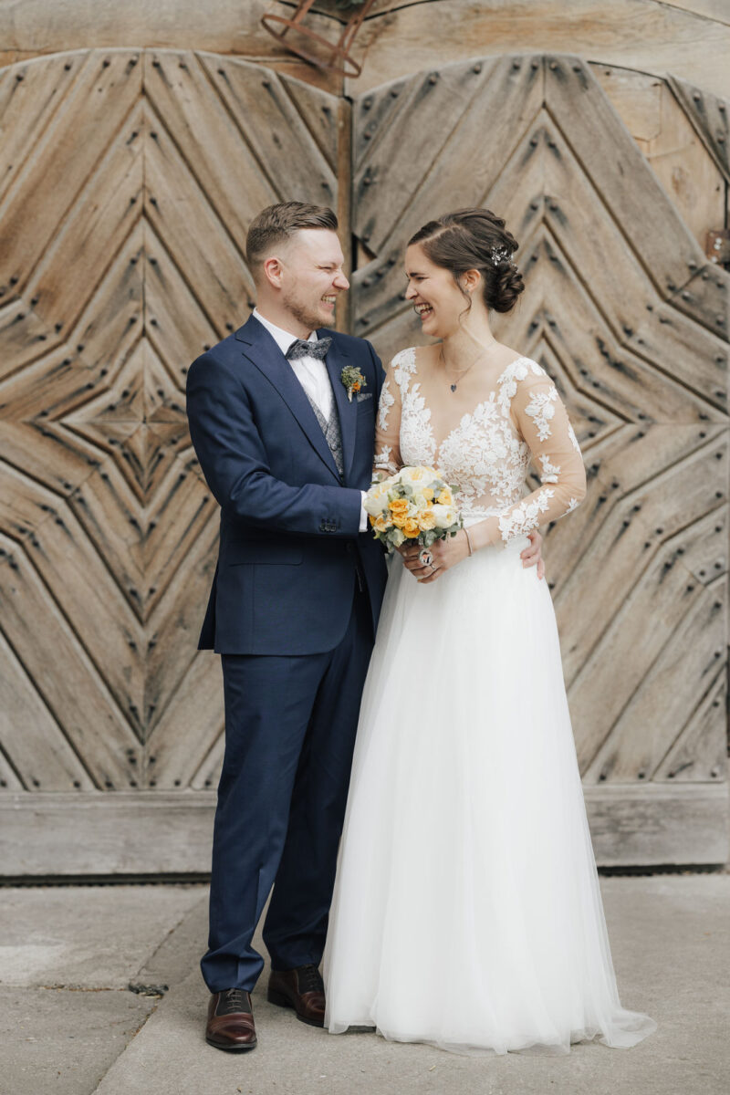 Brautpaar lacht sich an beim Brautpaarshooting an der Hochzeitslocation