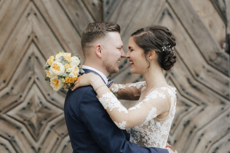 Brautpaar lacht sich an beim Brautpaarshooting an der Hochzeitslocation