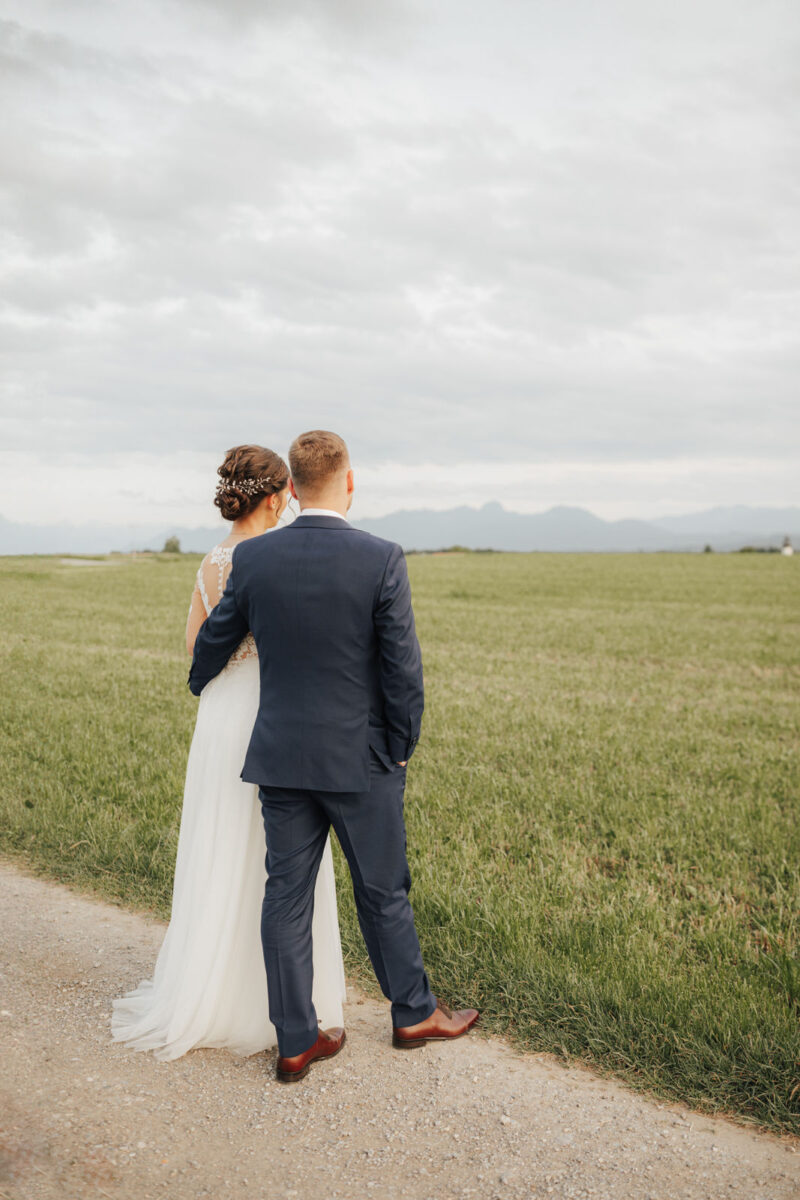 Brautpaar blickt in die Berge bei Brautpaarshooting zum Sonnenuntergang