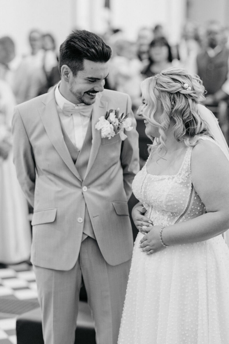 Brautpaar lacht sich während der Trauung in der Erlöserkirche Rosenheim an