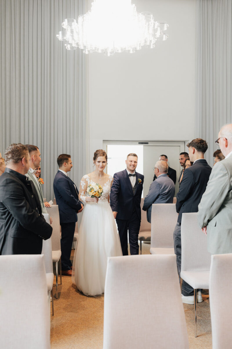 Das Brautpaar betritt den Trausaal im Standesamt Bad Aibling – emotionale Hochzeitsfotografie von Mona Gogg