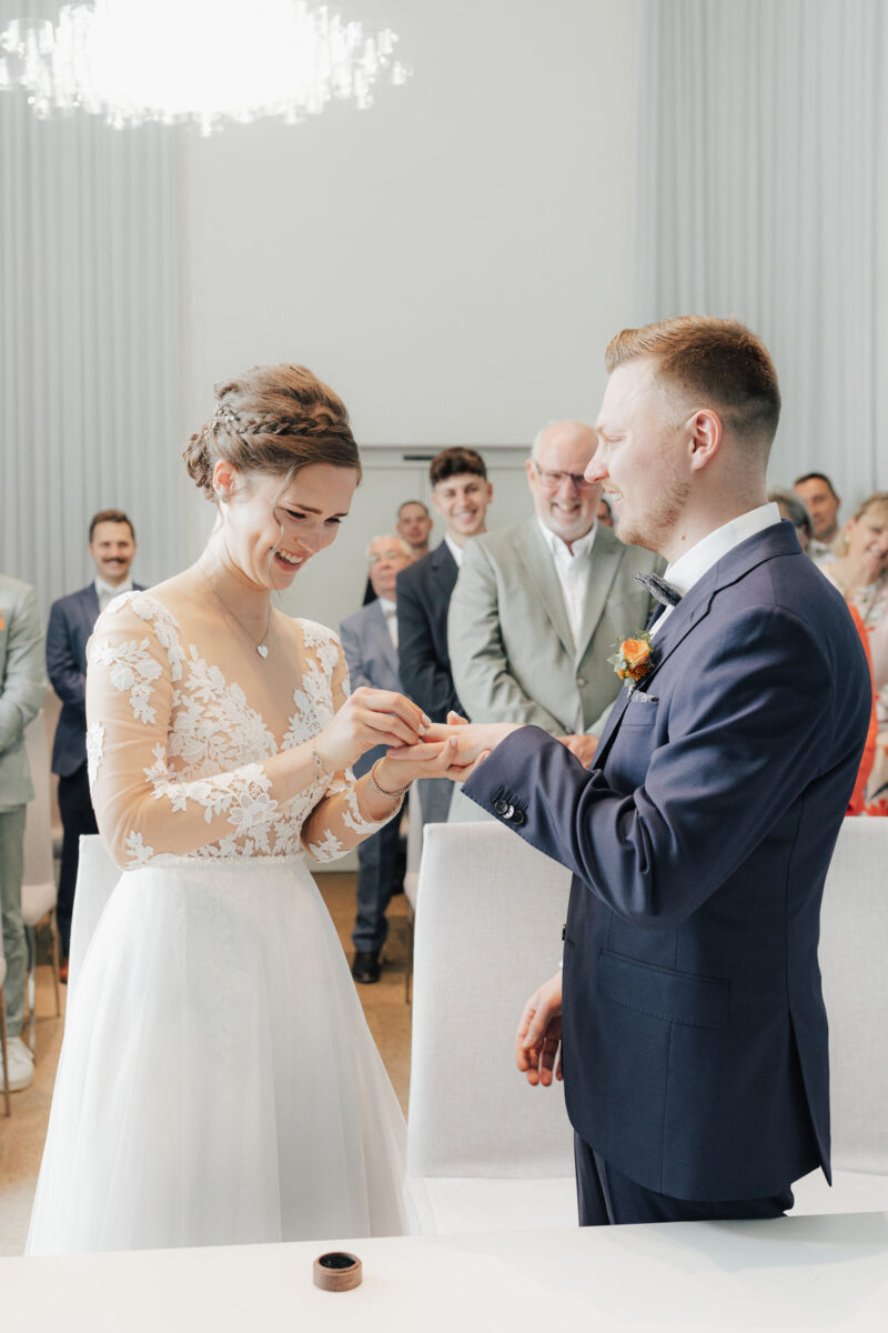 Ringtausch während der standesamtlichen Trauung im Standesamt Bad Aibling – Braut und Bräutigam stecken sich die Ringe an